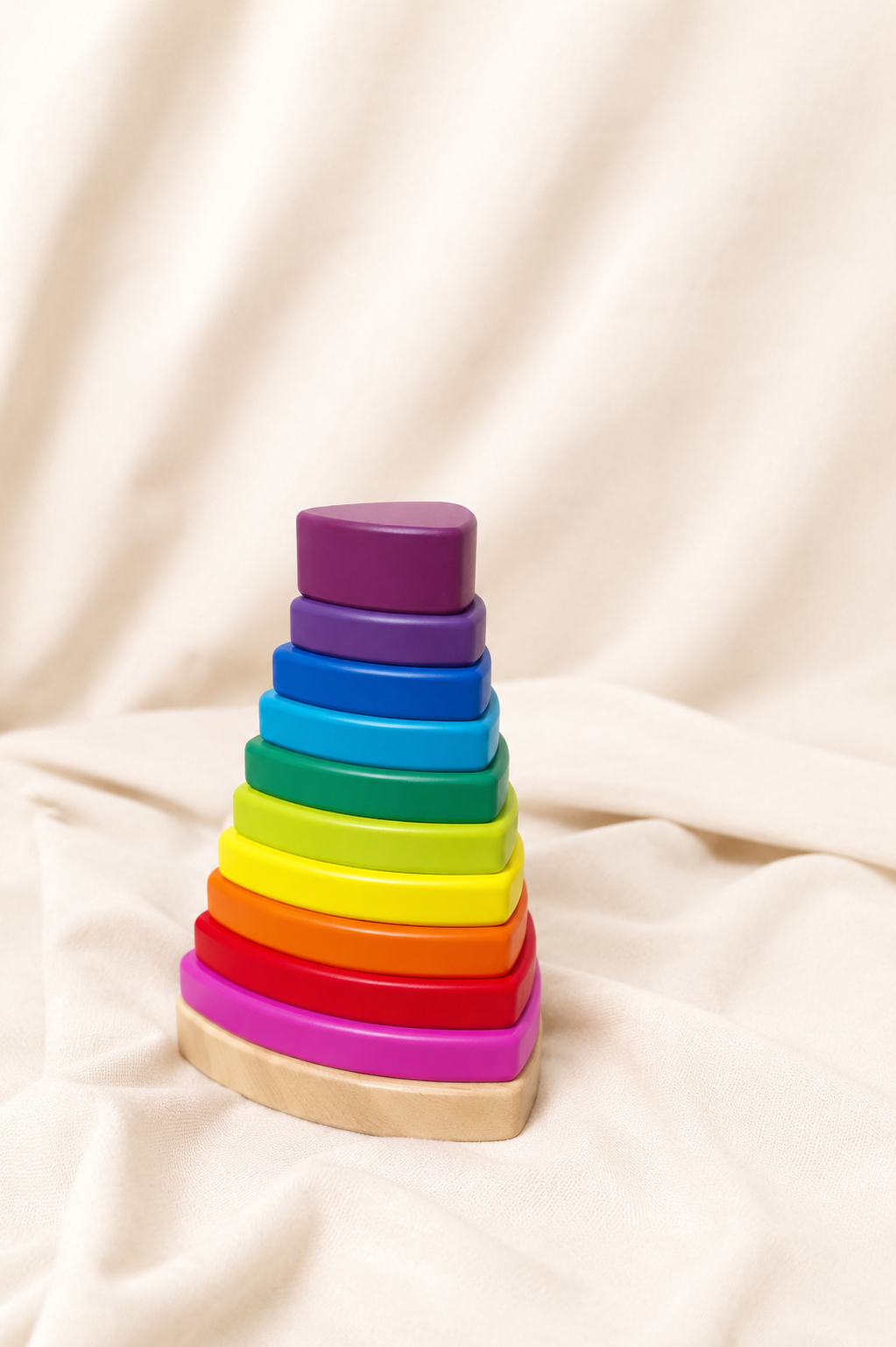 Colorful wooden stacking toy on a beige fabric background