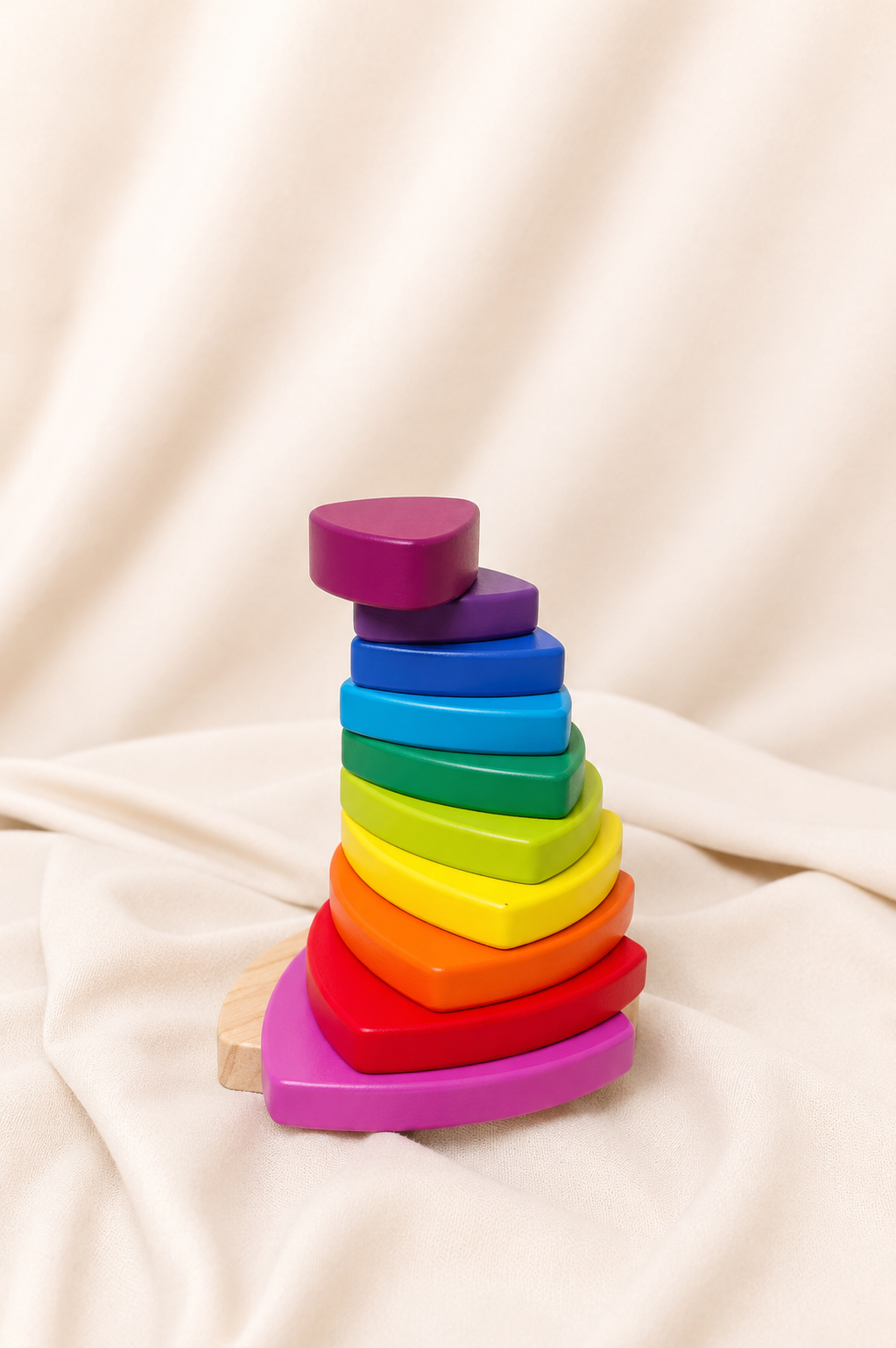 Colorful wooden stacking toy on a beige fabric background