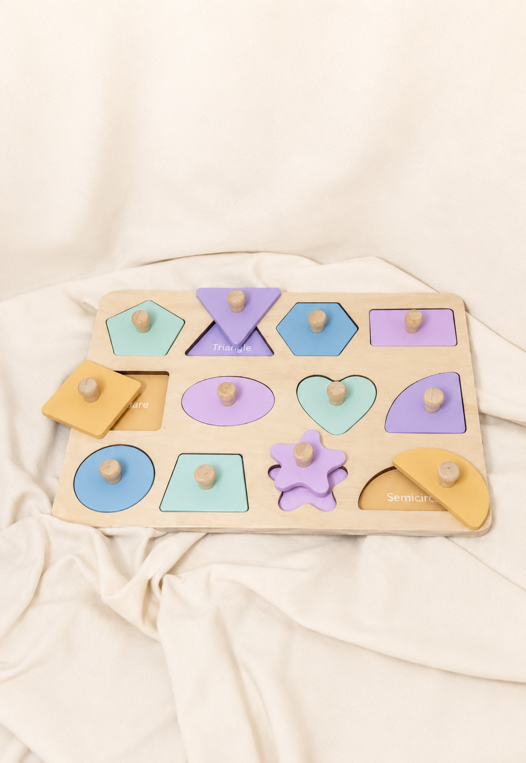 Wooden shape sorting puzzle with colorful shapes on a beige fabric background
