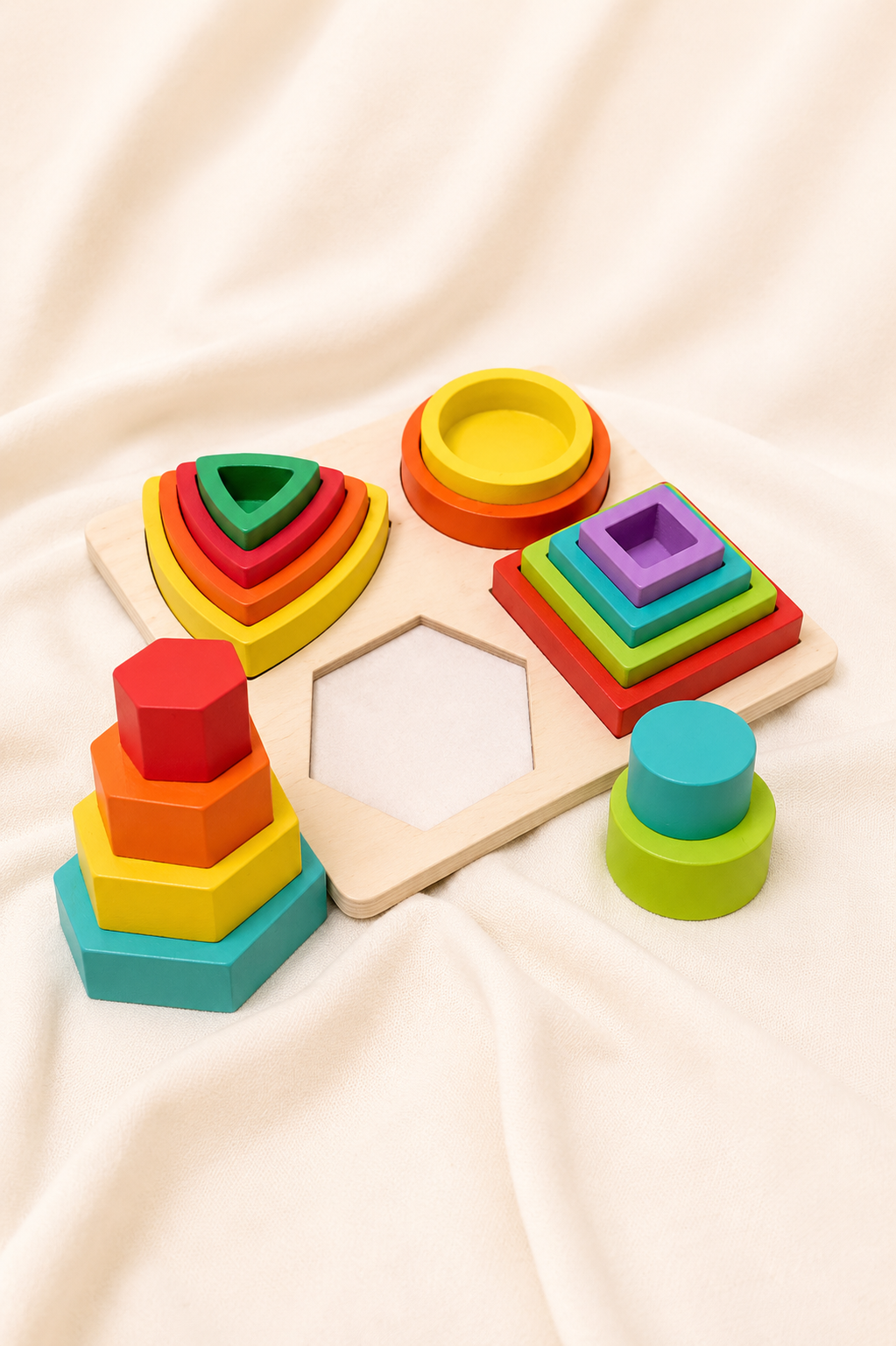 Colorful geometric stacking toys on a beige fabric background