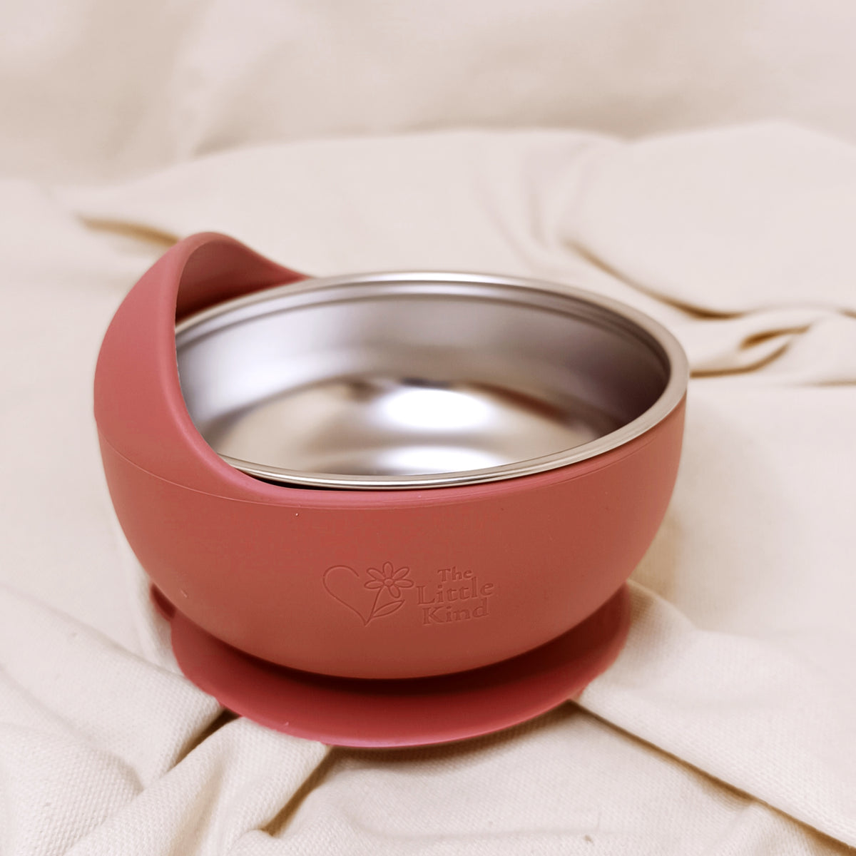 Pink baby bowl on a beige surface