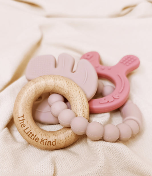 Teething ring with pink and wooden design on a soft beige background
